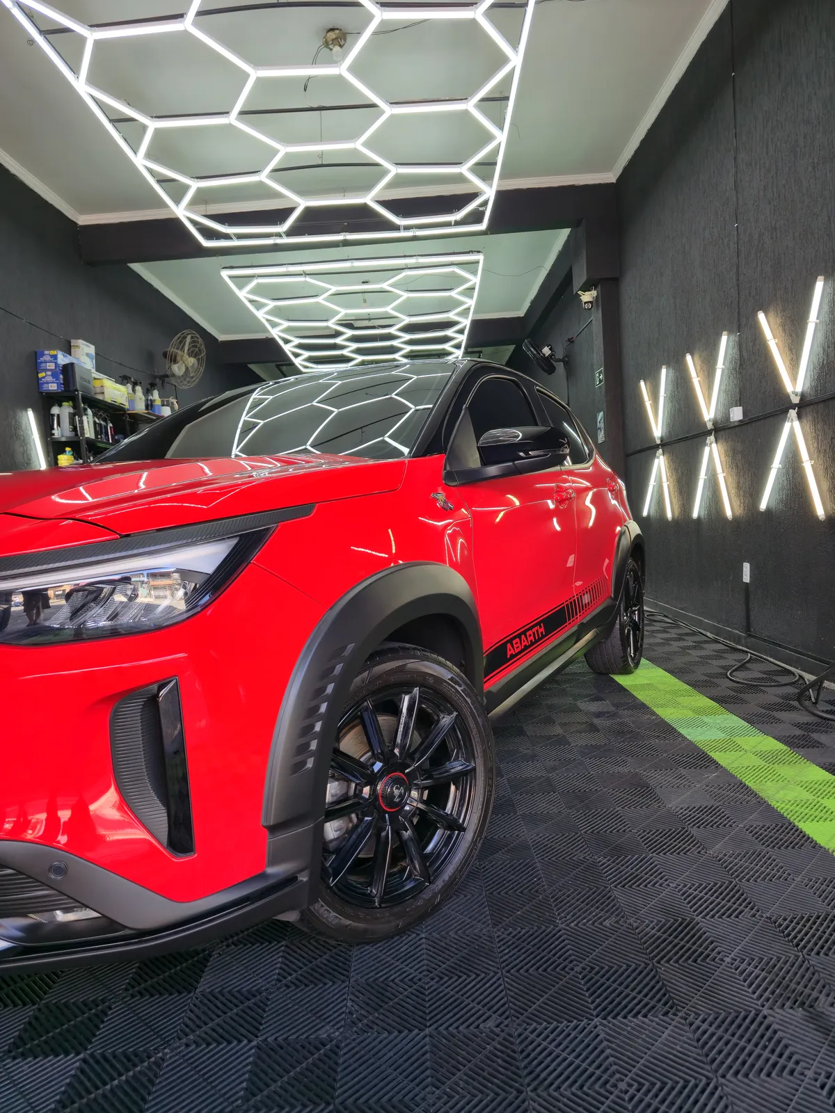 SUV vermelho polido sob o teto de LED da Bond's
